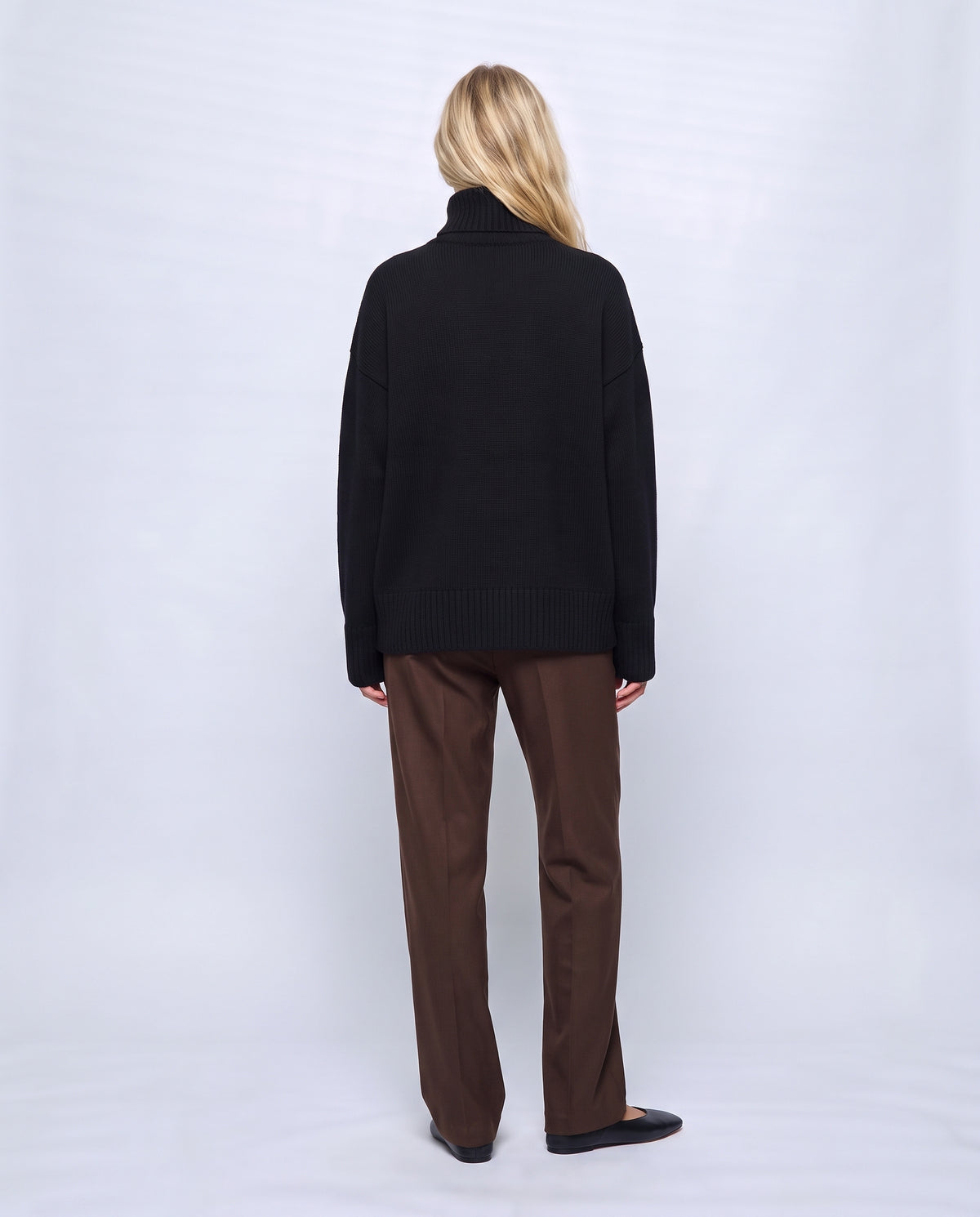Louise Relaxed Roll-Neck Sweater in Black, back view on a non-pregnant model