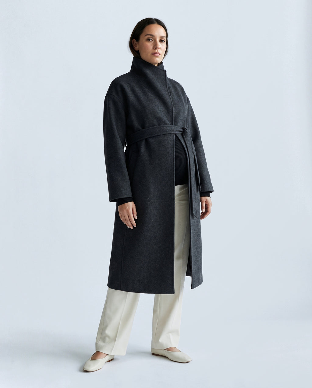 The Belted Stand-Collar Coat in Charcoal, closed over the bump
