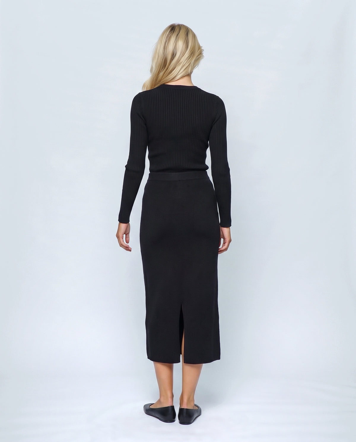 The Column Knit Skirt in Black, back view on a non-pregnant model