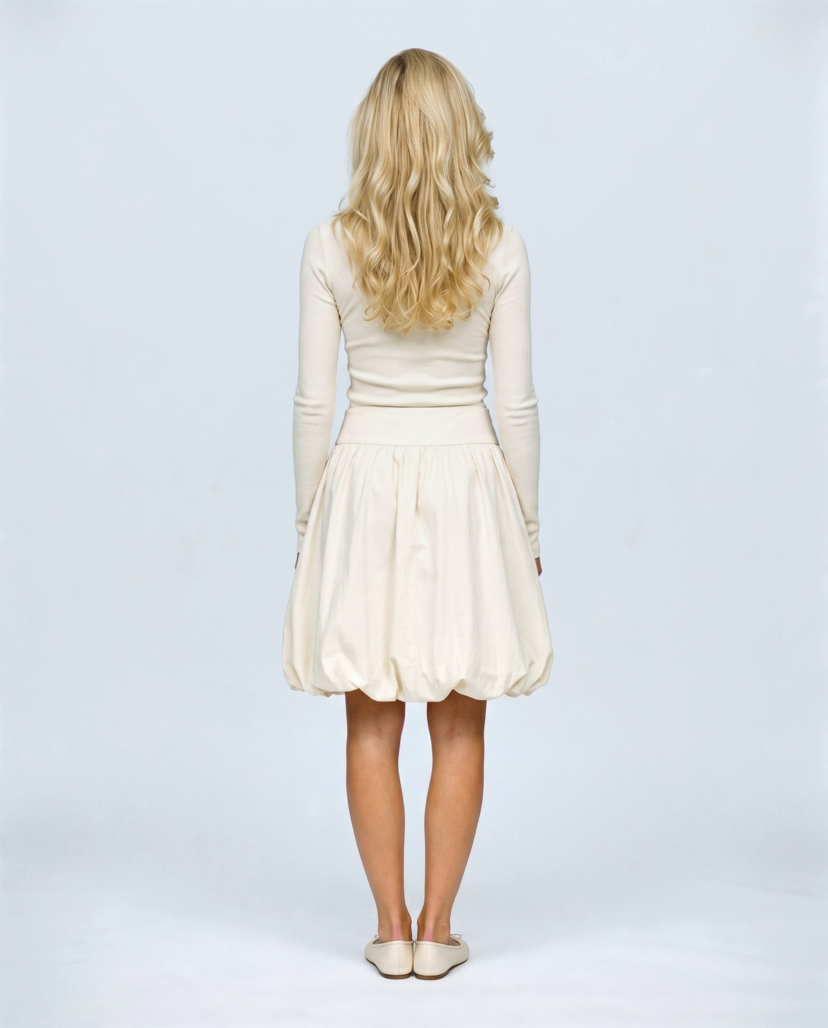 The Sculpted Tulip Skirt in Cream, back view on a non-pregnant model