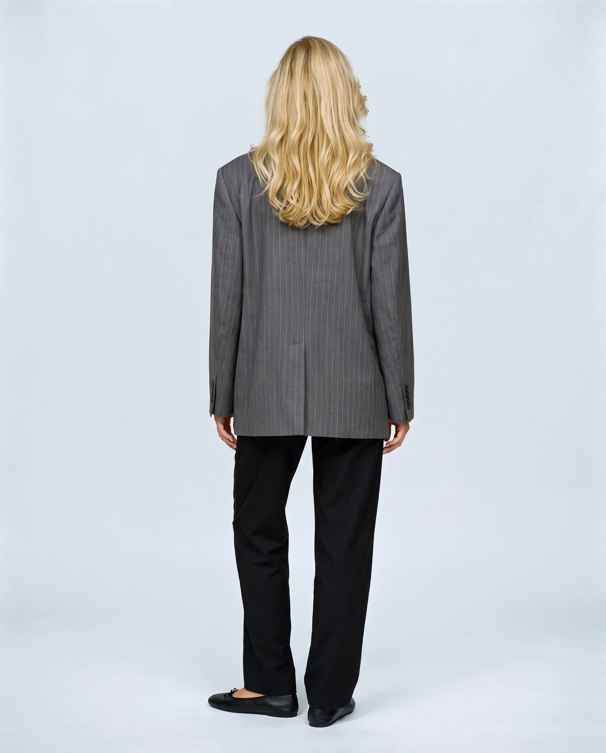 The Relaxed Pinstripe Blazer in Grey pinstripe, back view on a non-pregnant model